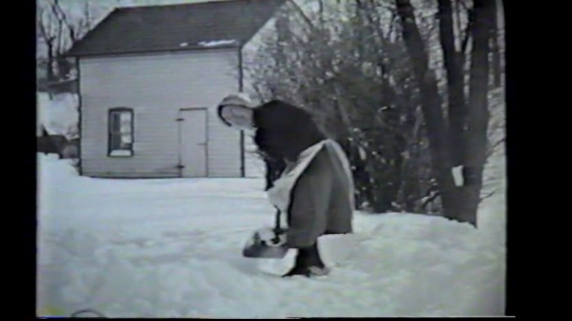 Grandma in sun-bonnet shoveling snow in Pennsylvania, 1950s