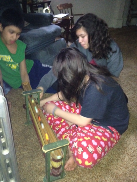 Gloria's grand-children playing with the same marble-roller we had as children: Demetri 12, Inani 13, and Samantha 10.