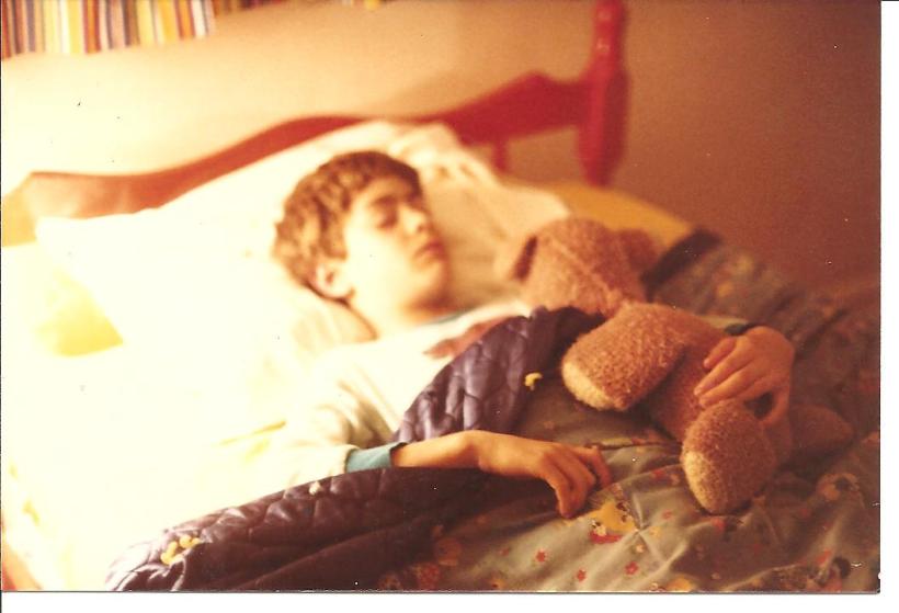Joel sleeping with teddy bear, age 8